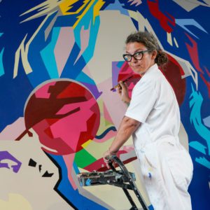 Kimberly painting Janis Joplin on a step ladder