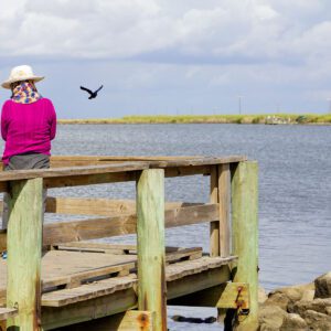 woman standing on the pier at mcfaddin national wildlife refuge in port arthur texas