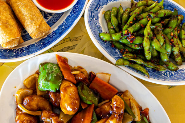 Sam You's China Inn in Port Arthur, TX dishes of egg rolls and sweet and sour sauce, spicy garlic edamame and spicy garlic chicken
