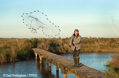 Biologist Alison Tarter throwing a net near Sabine Lake.