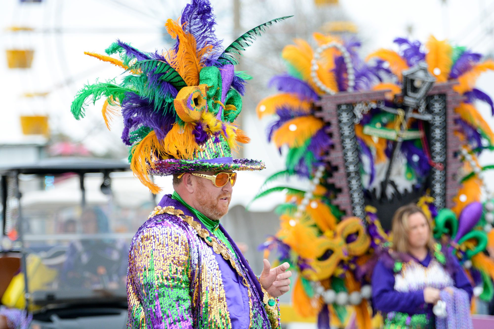 Man walking in a costumed parade handing out beads