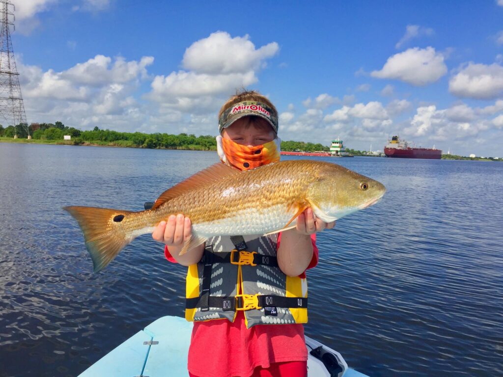 boy holding a redfish in port arthur