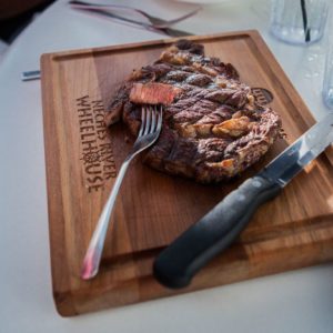 a cutting board holding a steak
