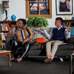 two people sitting on a couch during a performance at the port arthur little theater