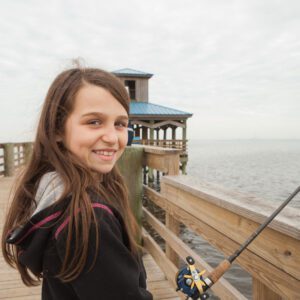 young girl fishing off the pleasure island pier in port arthur texas