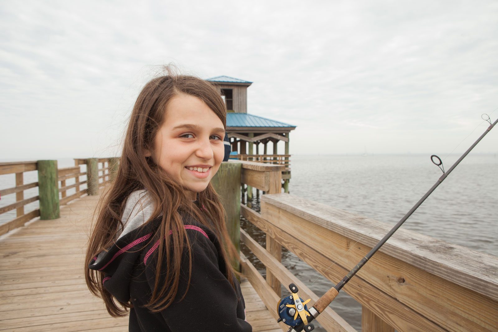 young girl fishing off the pleasure island pier in port arthur texas