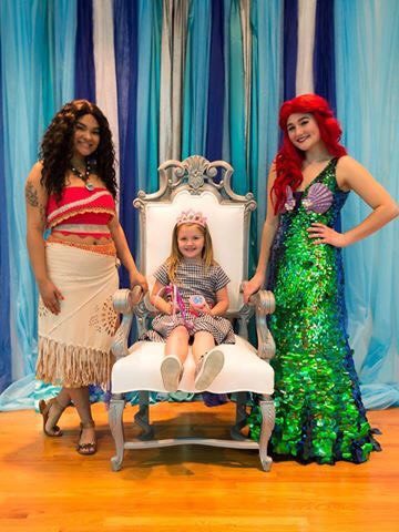 two mermaids and one little girl wearing a crow