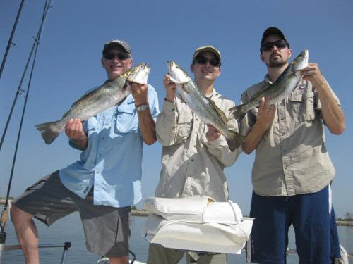 three men holding fish