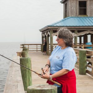 woman fishing from a wooden pier