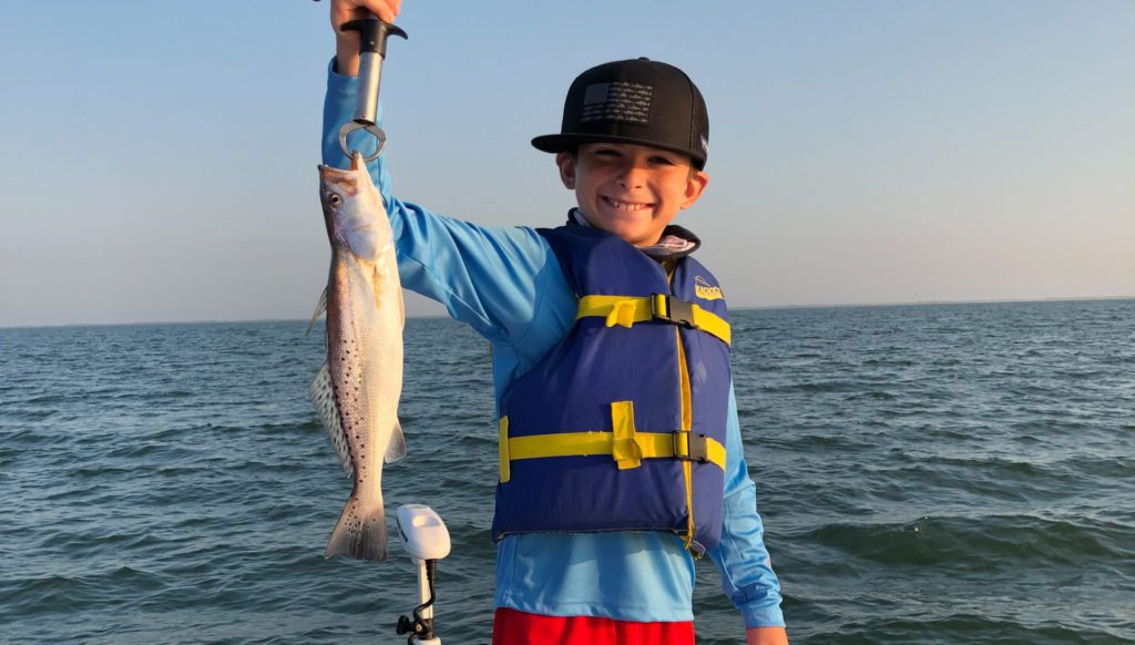 Fishing boy showing off trout in port Arthur, texas