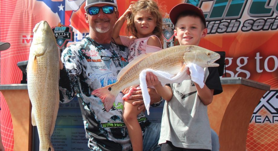 family in port arthur holding up a redfish
