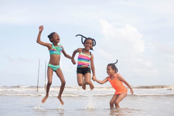 three girls jumping in the surf in port arthur texas