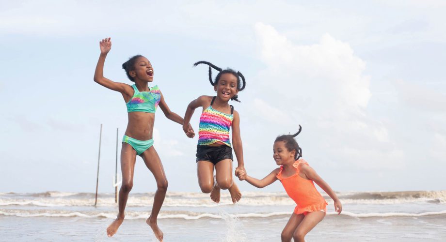 three girls jumping in the surf in port arthur texas