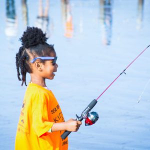 little girl shore fishing at sea rim