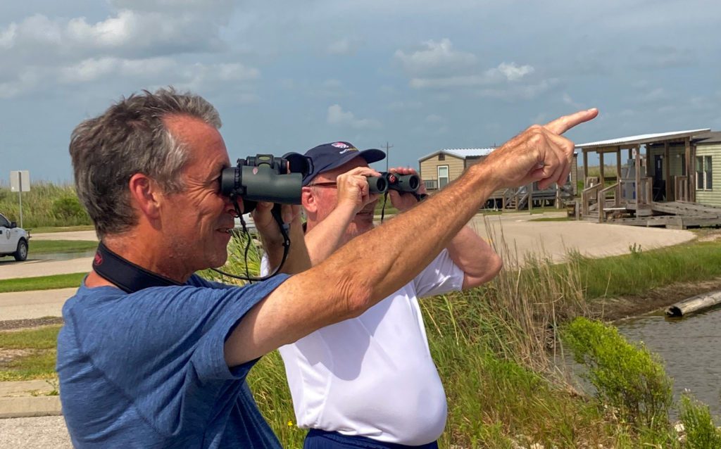 men looking through binoculars at sea rim state park in port arthur texas