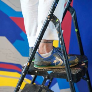 kim brown's feet as she paints Janis Joplin mural