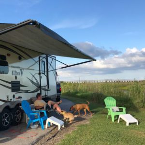 a man sitting next to his rv with his dogs at sea rim state park in port arthur texas