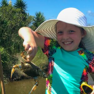 little girl showing off her crab catch at sea rim state park in port arthur, texas