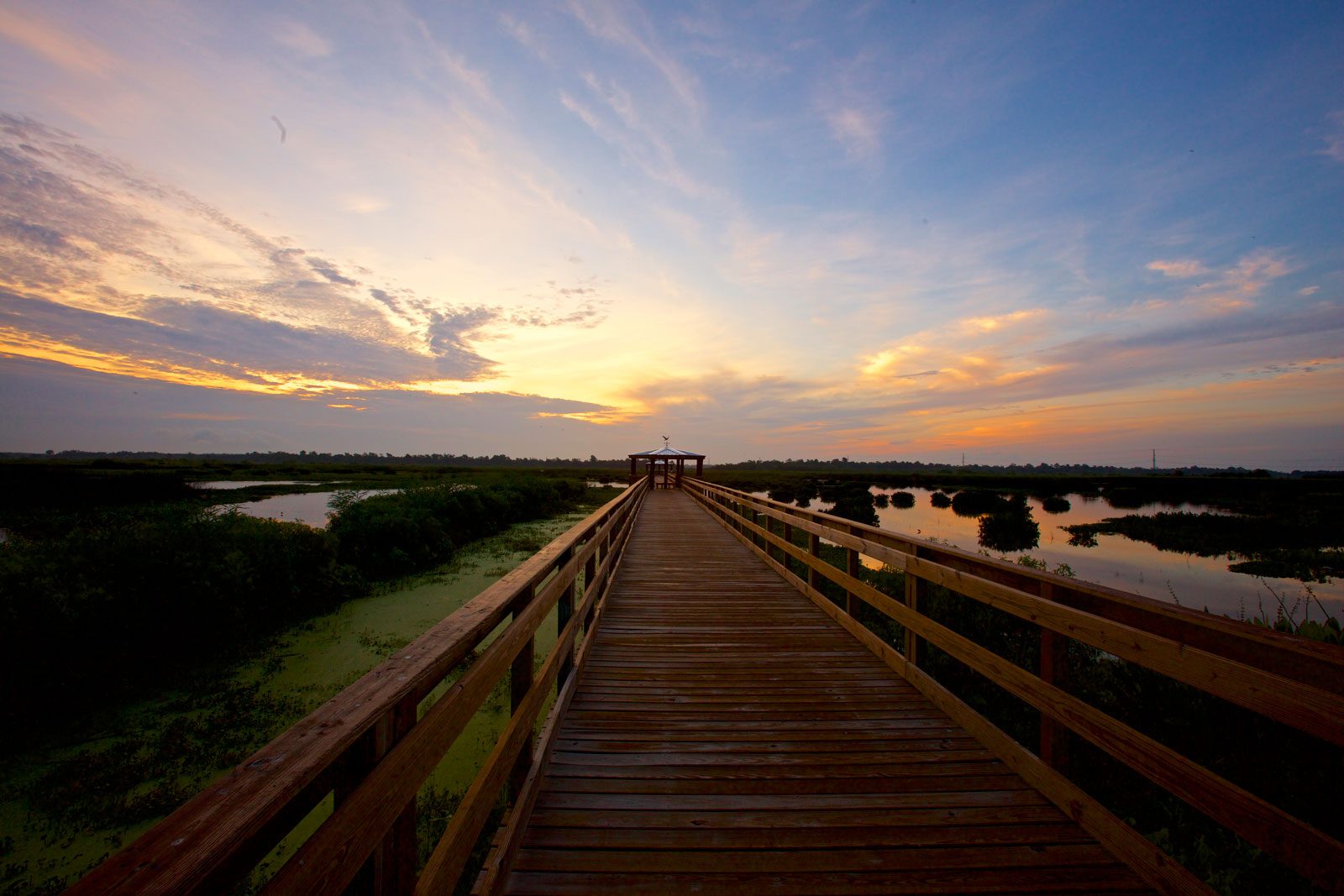 boardwalk with water at sunset in beaumont texas