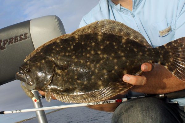 hands holding a flounder in port arthur, texas