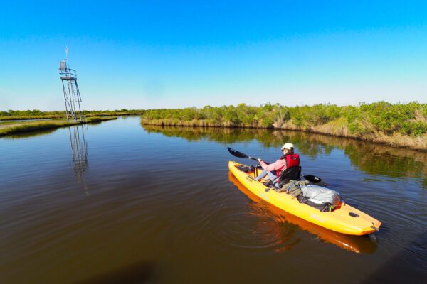 a girl paddles the marsh unit at sea rim state park in port arthur texas