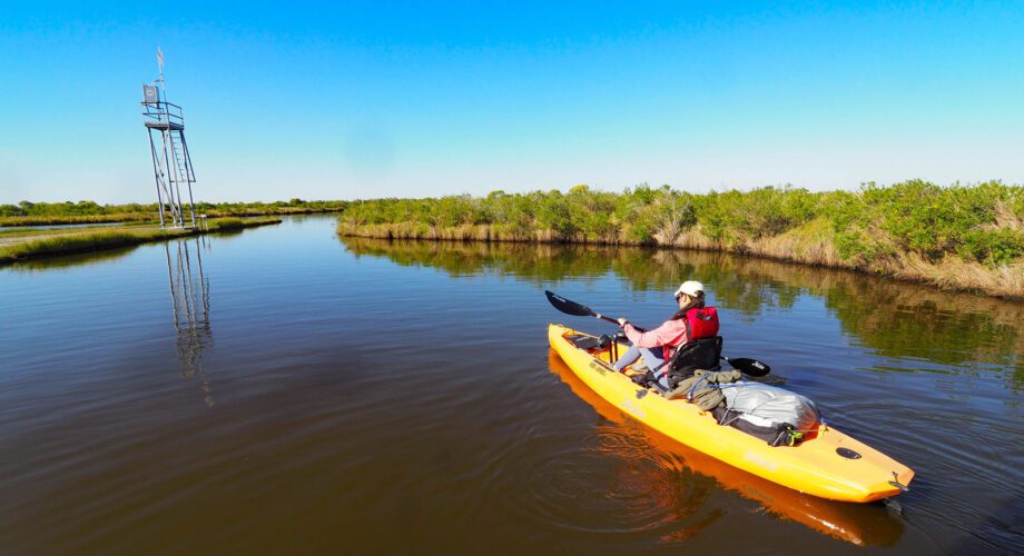 a girl paddles the marsh unit at sea rim state park in port arthur texas