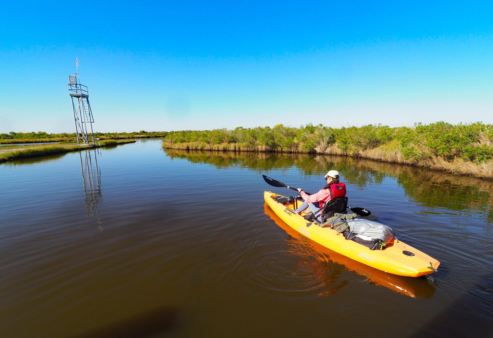 a girl paddles the marsh unit at sea rim state park in port arthur texas