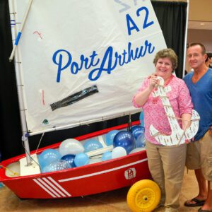people posing in front of a sailboat inside the civic center in port arthur