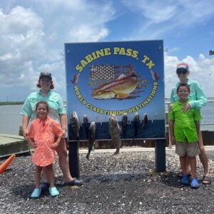 family posing with their day's fishing catch in sabine pass, a neighborhood of port arthur texas