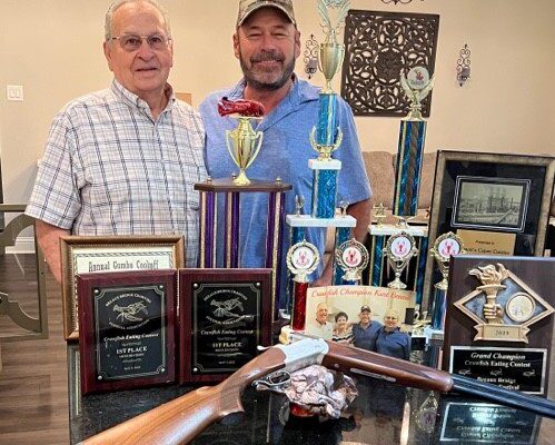 Kurt Benoit and father, John Benoit, with Kurt's Crawfish Eating Contest winnings.