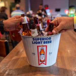 two hands reaching for a bucket of beer at pin and tonic in port arthur