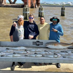 four guys showing off their days catch at sabine pass' fish cleaning station