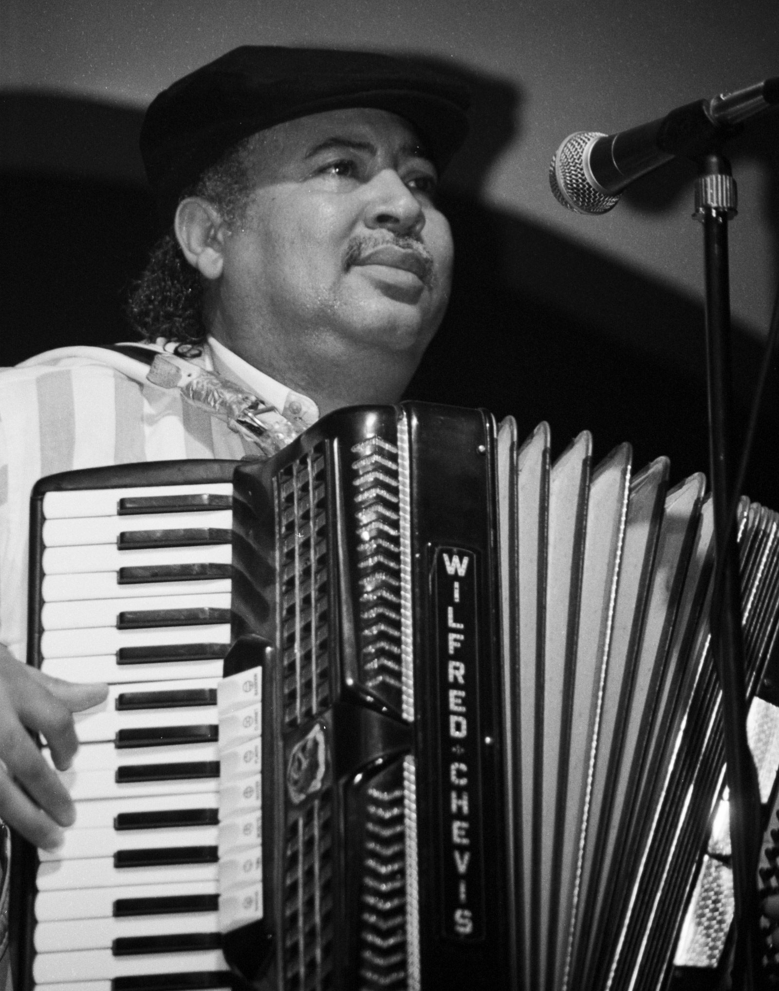 black and white image of zydeco musician manuel wilfred singing and playing an accordion