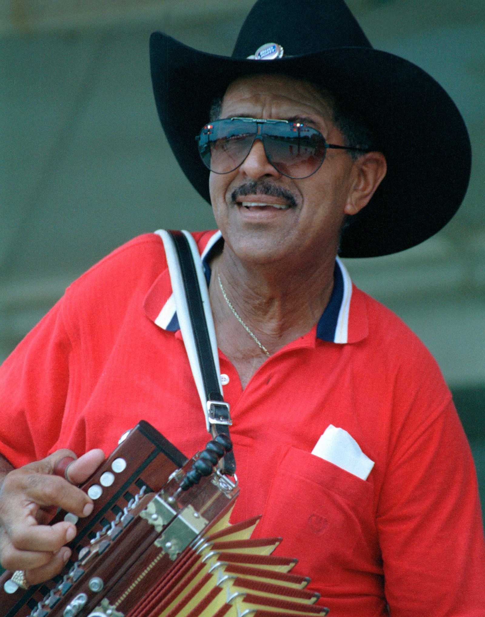 Willis Prudomme wearing a cowboy hat and playing zydeco music with his accordion