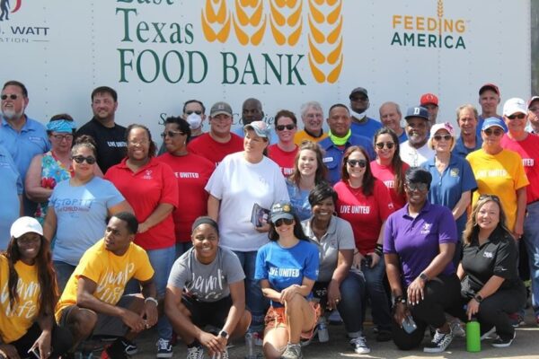 volunteers pose in front of a Food Bank truck after putting together food baskets for those in need in Port Arthur