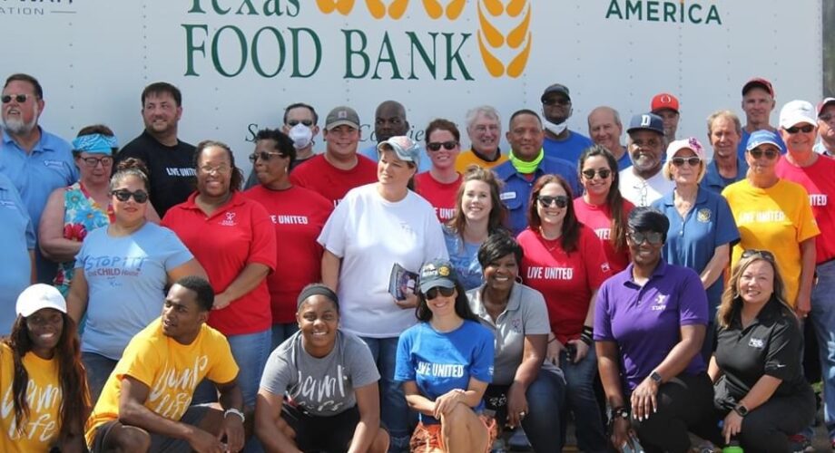 volunteers pose in front of a Food Bank truck after putting together food baskets for those in need in Port Arthur