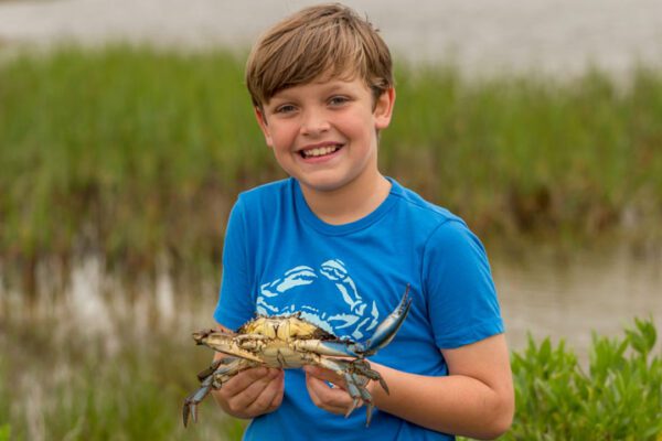 boy holding his crab at sea rim state park