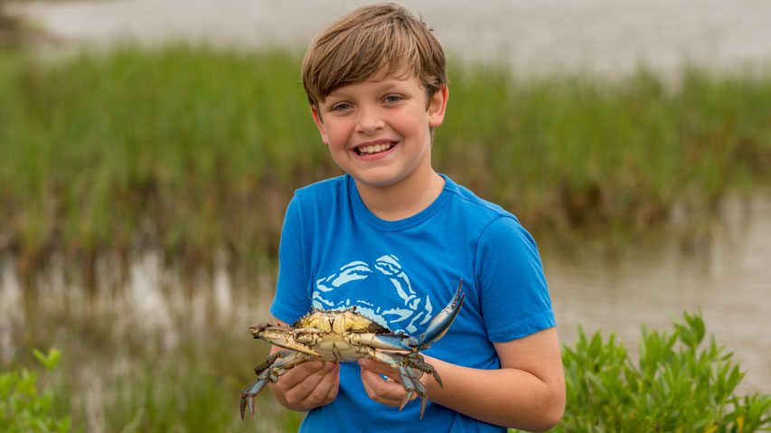 boy holding his crab at sea rim state park