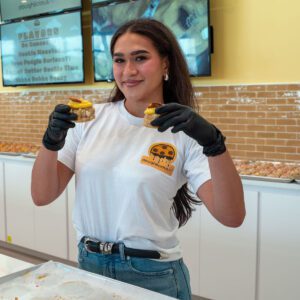 girl holding up two cookies at doughlicious in port arthur texas