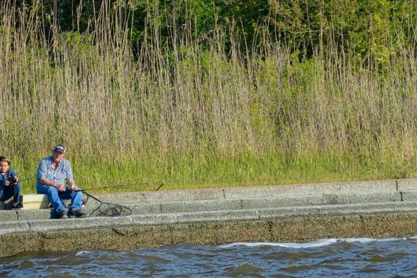 two men fishing the levy on pleasure island in port arthur