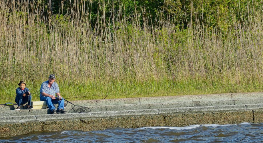 two men fishing the levy on pleasure island in port arthur