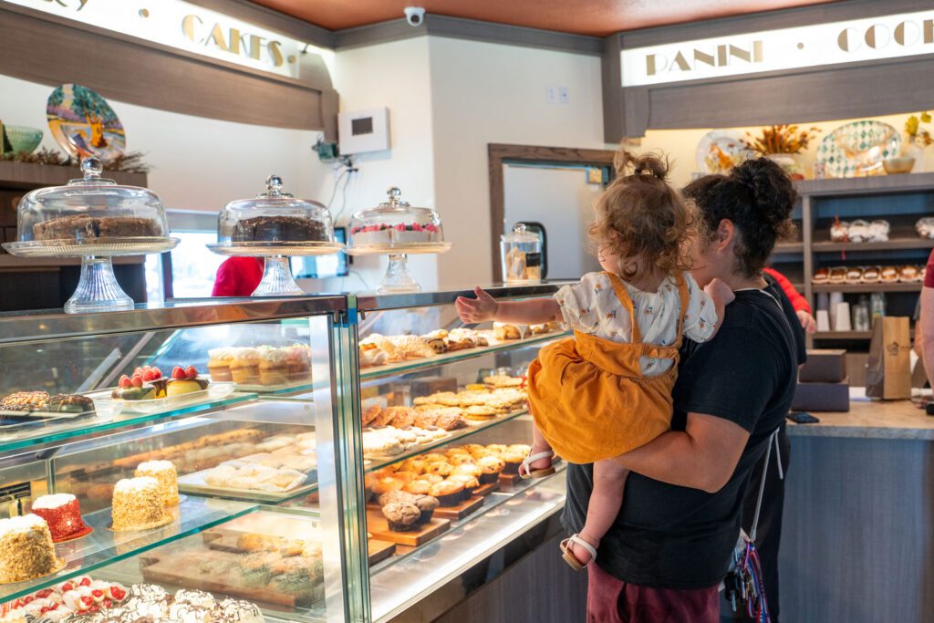 A woman holding her daughter while ordering a sweet treat at rao's bakery in port arthur texas