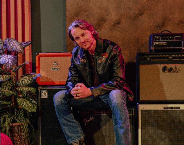 Tim Foust sitting on speaker in promo