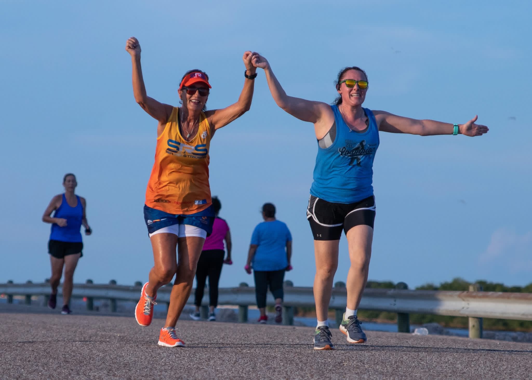 3 Bros Running Company runners along PA Seawall holding hands.