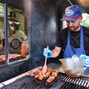 piggin out pork vendor cooking at the grill